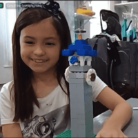 Screenshot of student smiling student showing her Big Ben creation from online LEGO class