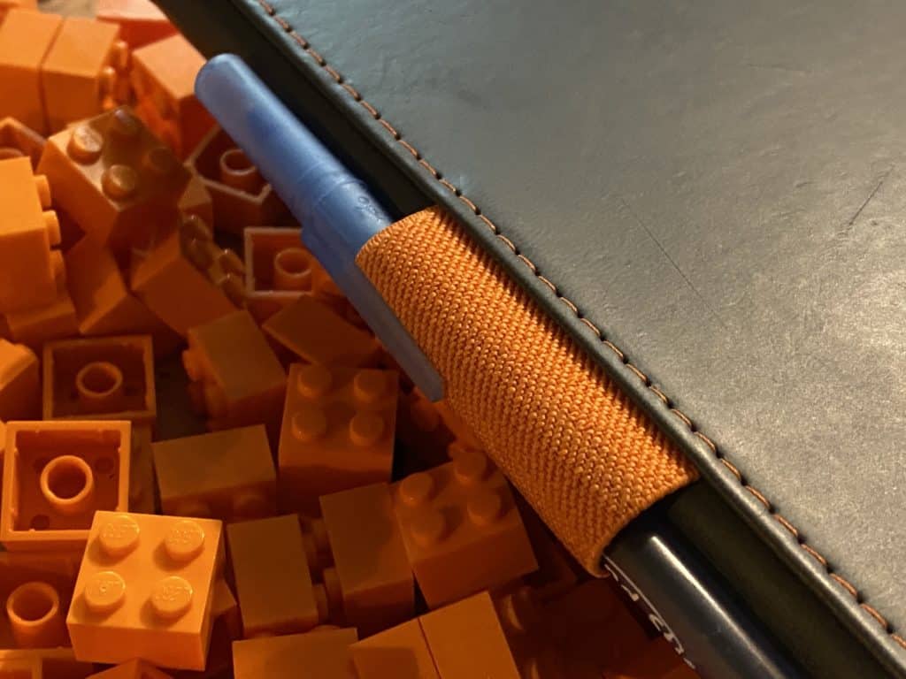 Photo of a journal with pen, sitting atop a pile of 2x2 orange bricks