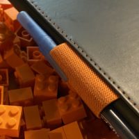 Photo of a journal with pen, sitting atop a pile of 2x2 orange bricks