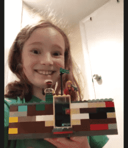 Screenshot of student smiling student showing her castle during online LEGO class